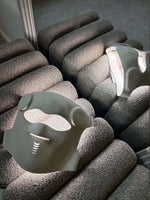 Led mask på en mjuk yta med sittande kuddar, designad för hemmabruk och avancerad ljusbehandling.
