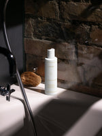 Hydrating toner i en vit flaska placerad vid handfatet, perfekt som ansiktstoner för hudvård.
